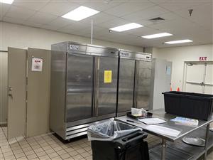 Kitchen in Community Building - view of prep table and upright fridge/freezer